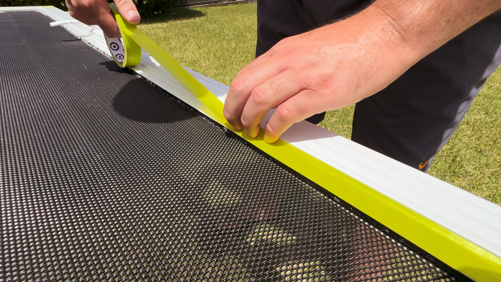 Applying painter's tape to screen door